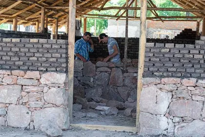 Gauchos levantando un muro de piedra