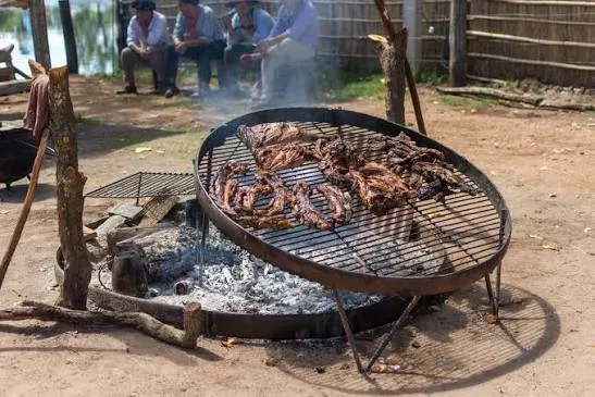 Asado criollo a las brasas en parrilla redonda